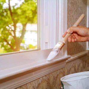 male-hands-repairs-painting-window-trim-at-home-closeup.jpg